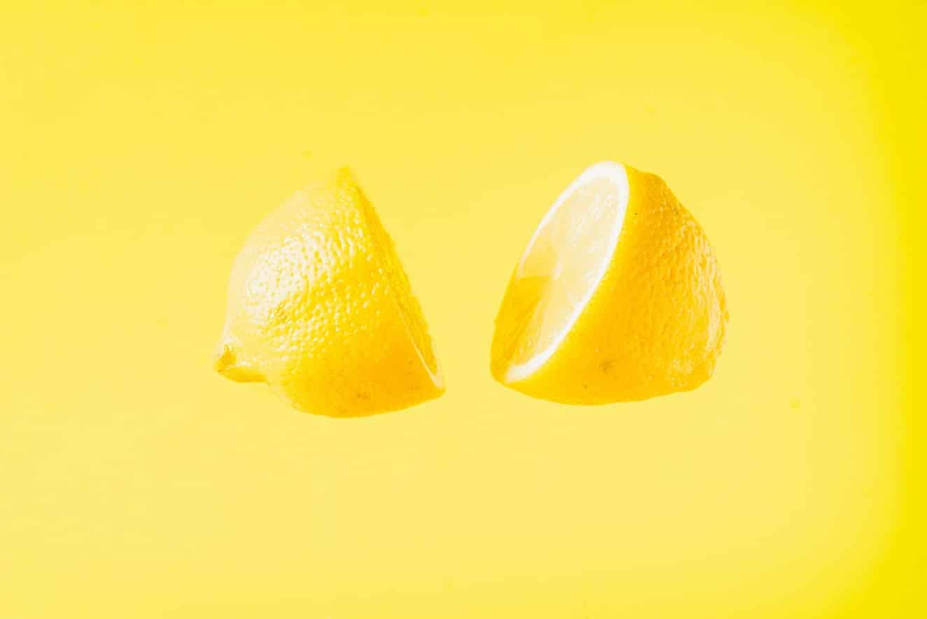 Sliced,Lemon,Floating,Against,Yellow,Background